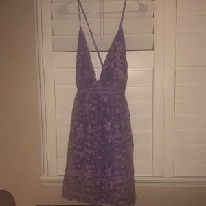 This is a purple dress with Flowers. It has a v neck.